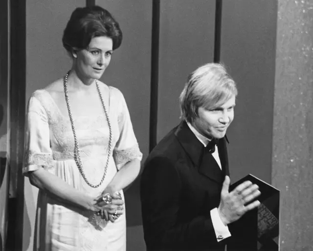 John Voight, ganador del premio al recién llegado más prometedor en papeles principales en cine por su rol en "Cowboy de medianoche" (1969), con la presentadora Vanessa Redgrave en los Premios de la Sociedad de Artes Cinematográficas y de Televisión, el domingo 8 de marzo de 1970, London Palladium, Londres.