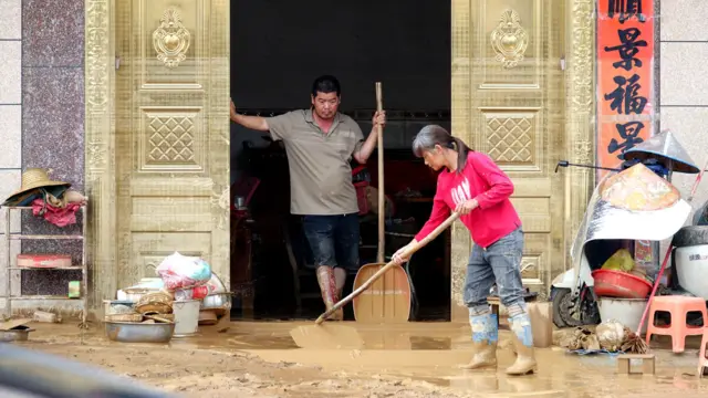 中國廣西南寧橫州市，村民在洪水退卻後清理泥濘，穿著水靴的中年男子一臉無奈（7/7/2026）