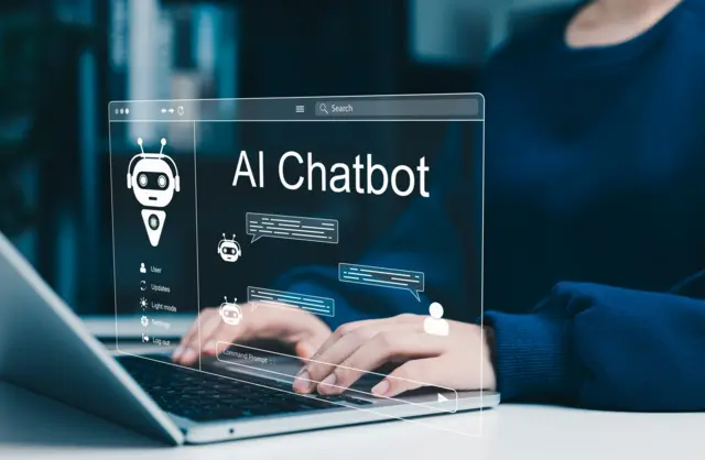 صورة تعبيرية لمستخدم يتفاعل مع روبوت دردشة عبر الحاسوب المحمول، مع ظهور رسائل المحادثة وأدوات الأتمتة وتقنيات المساعد الذكي لدعم العملاء الرقمي