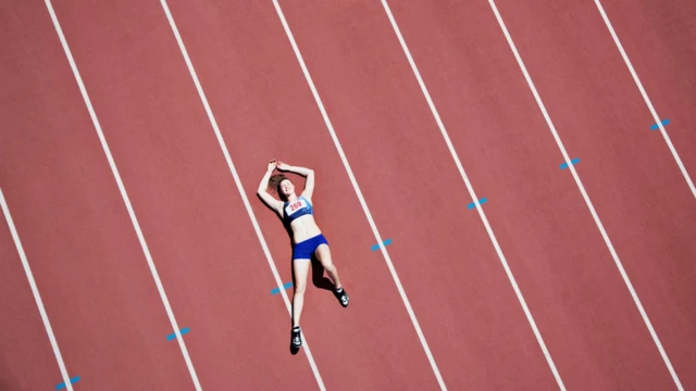 Coureuse allongée sur la piste d'athlétisme