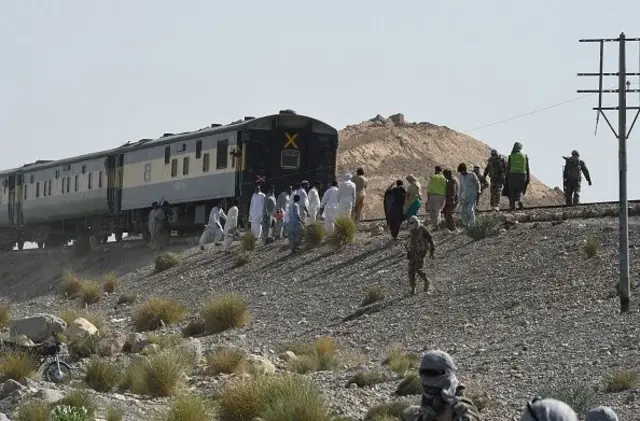 یو اورګاډی پر پټلۍ ولاړ دی او ګڼ کسان یې شاوخوا راټول دي چې امنیتي خلک هم پکې ښکاري.