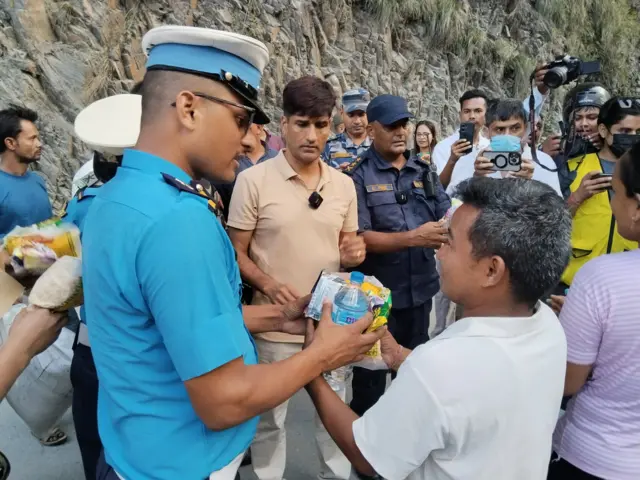 राजमार्गमा अलपत्र परेका यात्रुलाई खाजा बाँड्दै प्रहरी