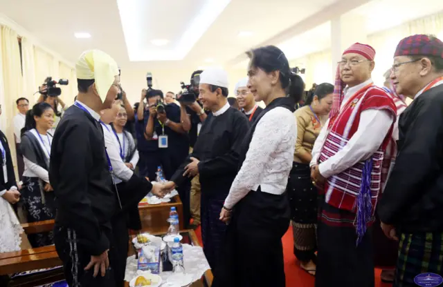 ဒေါ်အောင်ဆန်းစုကြည်နဲ့အတူ အာဇာနည်မိသားစုဝင်တွေကို နှုတ်ဆက်နေတဲ့ မန်းဝင်းခိုင်သန်း