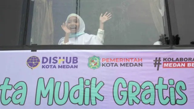Pemudik melambaikan tangan saat pelepasan Mudik Gratis 2023 di Jalan Masjid Raya, Kota Medan, Sumatera Utara, Rabu (19/04)