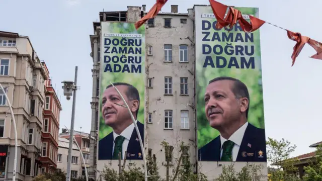 İstanbul'da bir bina. Üzerinde Erdoğan'ı gösteren dev posterler. "Doğru zaman doğru adam" yazıyor. 
