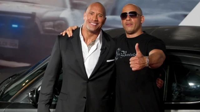 دواین جانسون و وین دیزل که دست در گردن او انداخته روبروی دوربین عکس گرفته‌اند و دیزل انگشت شصتش را به علامت موفقیت نشان می‌دهد