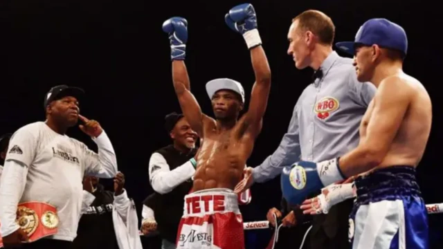 Tete, wearing red and white boxers shorts wit im name on it, dey celebrate afta e win a boxing fight