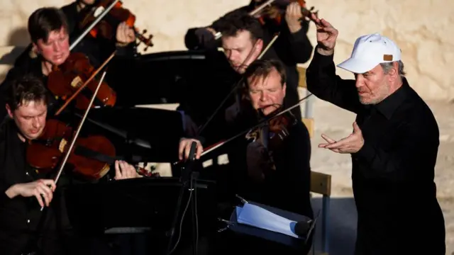 Белгилүү дирижер жана Владимир Путиндин ишенимдүү адамы Валерий Гергиев Пальмирадагы концертте оркестрге жетекчилик кылууда