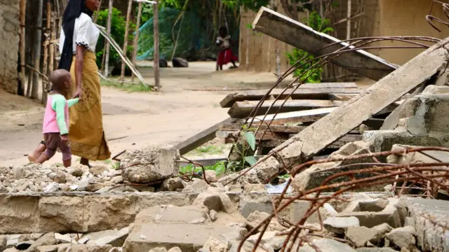 Moradores caminham pertovbet trustpilotmesquita destruídavbet trustpilotMocimboa da Praia