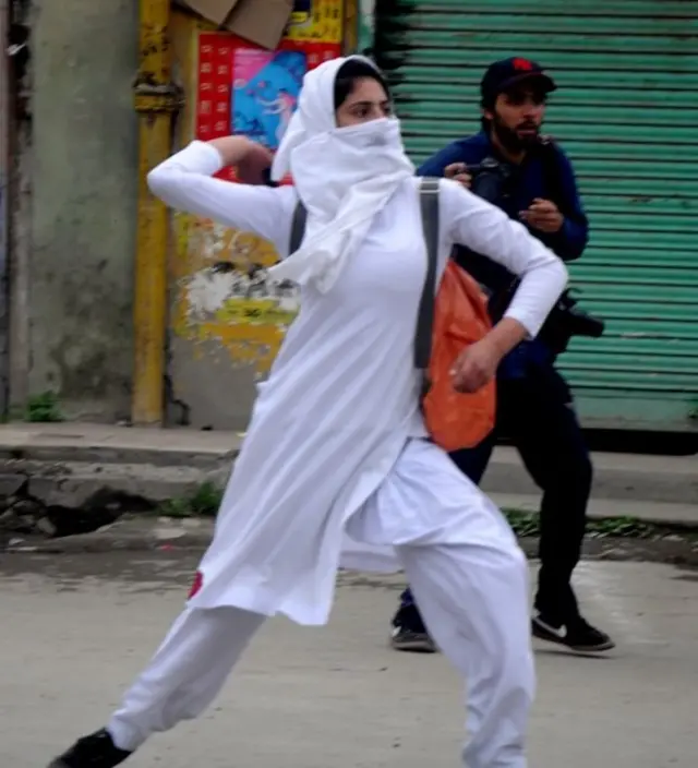 பாதுகாப்புப் படையினர் மீது கல் வீசும் பெண்