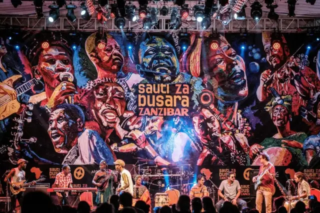 African musicians perform in front of a huge mural on stage at the 16th International African music festival 'Sauti za Busara' at the Old Fort in Stone town, Zanzibar, on 8 February 2019.
