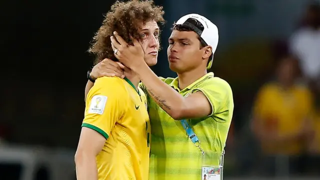 ২০১৪ বিশ্বকাপের সেমিফাইনালে জার্মানির কাছে ৭-১ গোলে হারার পর কান্নায় ভেঙ্গে পড়েন ব্রাজিলের ডিফেন্ডার ডাভিড লুইজ। তাকে স্বান্তনা দিচ্ছেন থিয়াগো সিলভা।