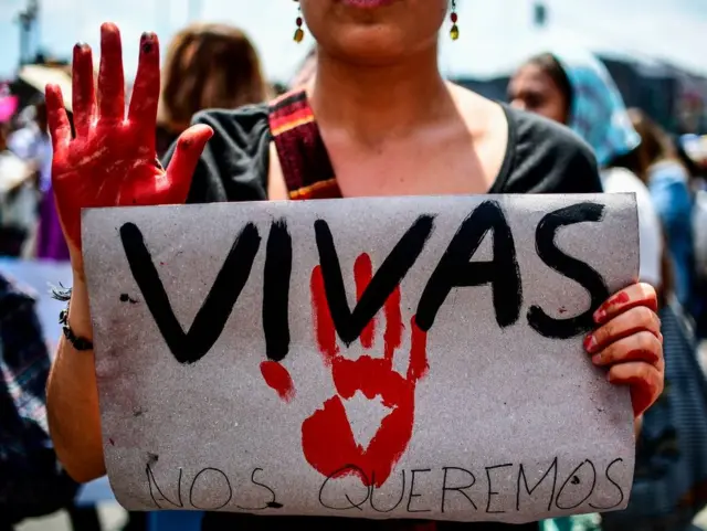Una mujer sostiene un cartel en una marcha de mujeres