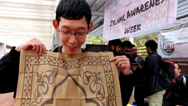 回族中国留学生马沛聪展示随身携带以做礼拜的便携式地毯。