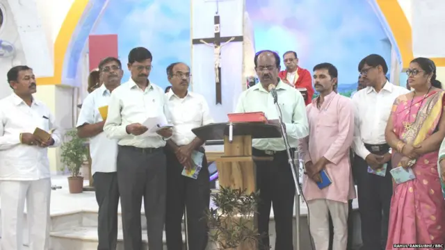 चर्चमध्ये प्रार्थना करणारे नागरिक