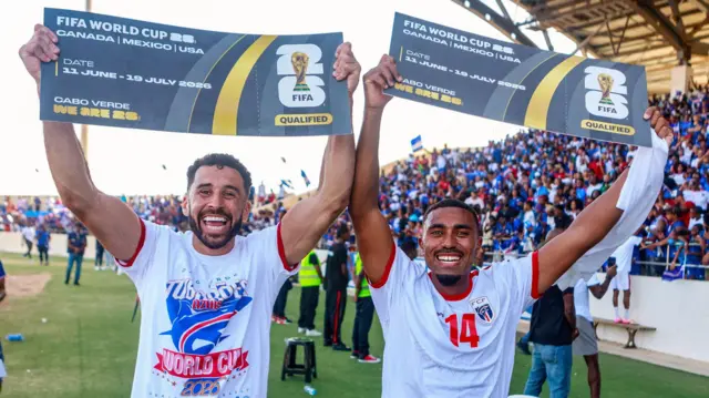 Os jogadores de futebol Roberto Lopes e Deroy Duarte comemoram a classificação de Cabo Verde para disputar sua primeira Copa do Mundo, no Estádio Nacional da Praia, em 13 de outubro de 2025