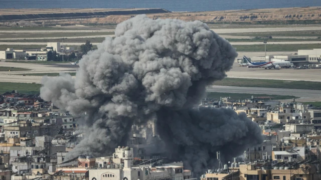 Coluna de fumaça subindo do local de um ataque aéreo israelense dirigido ao bairro de Al Lailaki, no sul de Beirute, com o aeroporto internacional da cidade visível ao fundo, no dia 4 de março de 2026