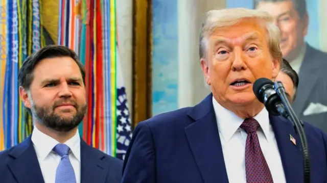 O presidente americano, Donald Trump discursa durante um evento acompanhado do vice-presidente JD Vance. Atrás deles há um retrato do ex-presidente dos EUA, Ronald Reagan