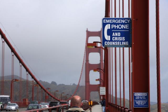 Placa em ponte menciona 'Telefone de emergência e conselhos em momentos de crise'