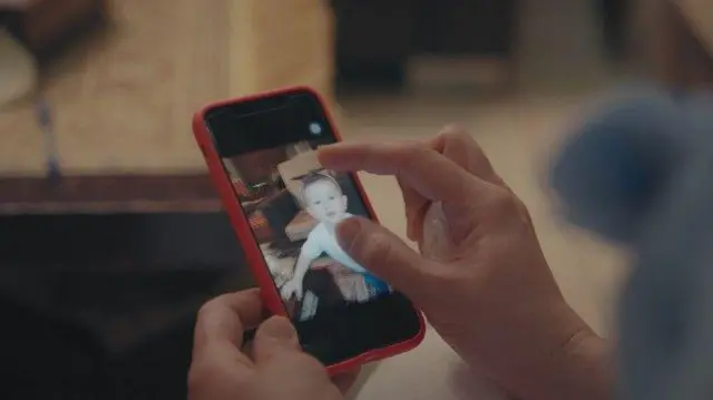 أُمّ تستعرض صورة طفلها المفقود 