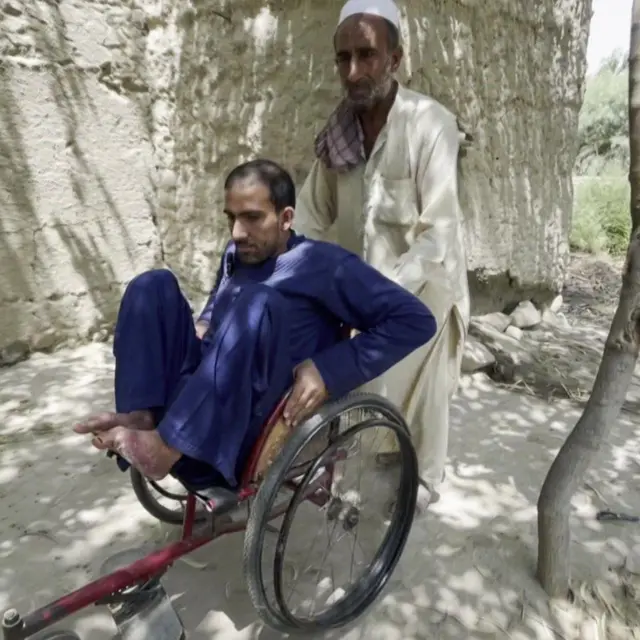رجل يدفع آخر على كرسي متحرك
