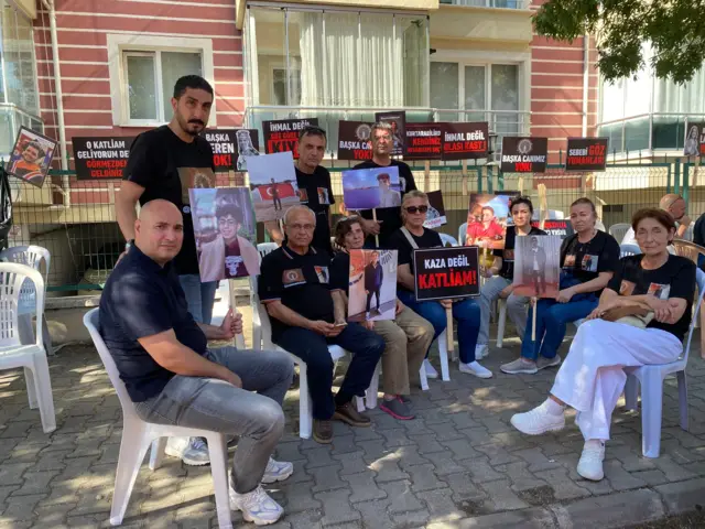 Ellerinde pankart ve fotoğraflar tutan yakınların fotoğrafları.