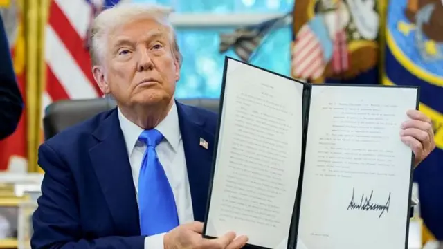 এক লাখ ডলার ফি নেওয়ার আদেশ সেপ্টেম্বরে স্বাক্ষরের পর তা দেখাচ্ছেন প্রেসিডেন্ট ট্রাম্প।