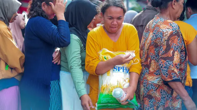 Seorang warga berusaha keluar dari antrean usai membeli beras dan susu saat Gerakan Pangan Murah di Pinang Merah, Alam Barajo, Jambi, Rabu (06/03).
