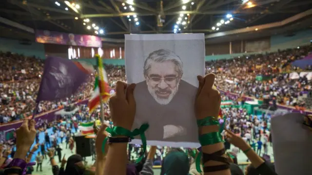 Una simpatizante del presidente reformista y candidato a las elecciones presidenciales de 2017, Hassan Rouhani, sostiene un retrato de Mir-Hosein Musaví