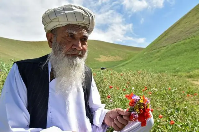 مردی که دسته گل شقایق در دست دارد
