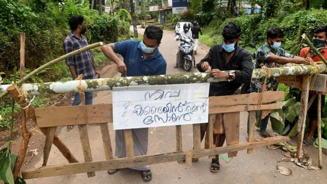 Warga memasang tanda berbunyi "Zona pengendalian Nipah" di barikade unttuk mencegah penyebaran virus Nipah di Desa Ayanchery, distrik Kozhikode, negara bagian Kerala.