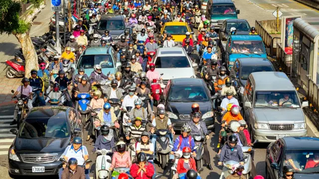 Una calle colapsada de motociclistas y autos.
