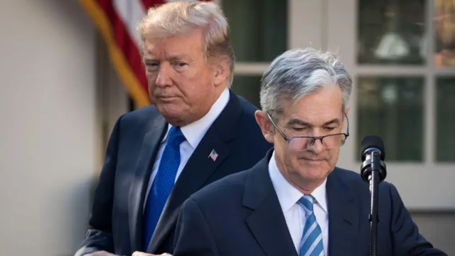 جروم پاول پشت میکروفون، پشت سر او دونالد ترامپ