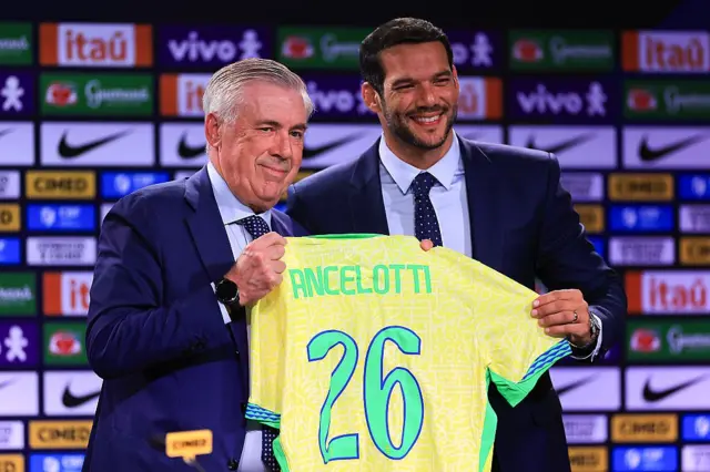 Ancelotti e o presidente da CBF exibindo camisa do Brasil com nome do técnico italiano e o número 26
