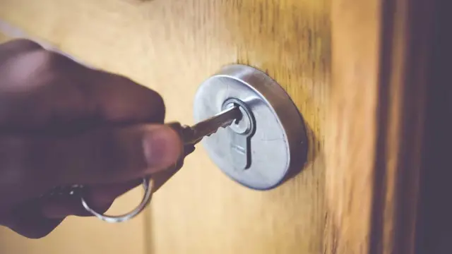 شخص يفتح الباب بالمفتاح
