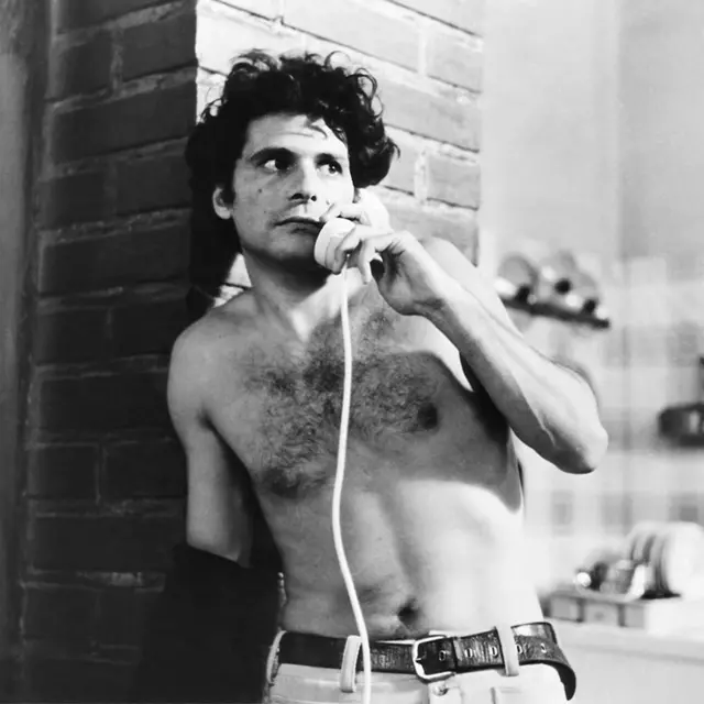 Чоловік з оголеним торсом і телефонною трубкою в руках - чорно-біле фото 