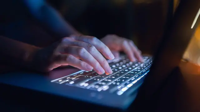 एक इंसान किबोर्ड पर टाइपिंग करते हुए