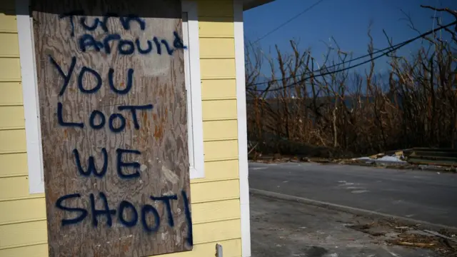 Cartel que dice "Date la vuelta, si saqueas, disparamos".