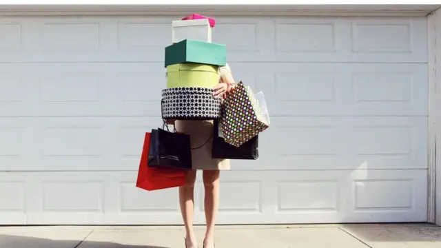 一女士抱著許多採購的物品