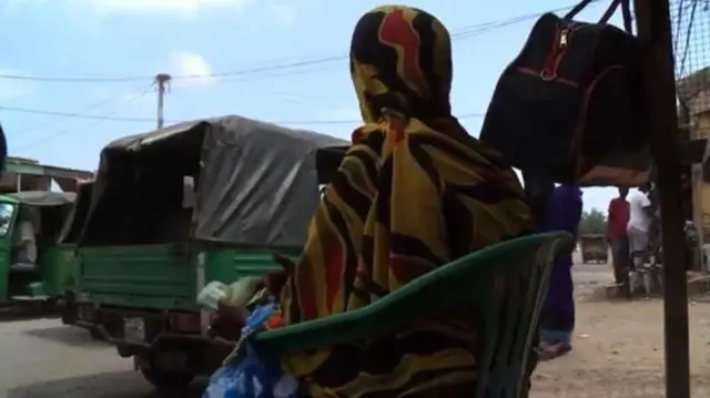 ገንዘብ ዘርዛሪዎቹ ሶማሌያውያን ሴቶች በእግረኞች እና በተሽከርካሪዎች በተጨናነቀው የጅቡቲ ጠባብ መንገድ ዳር ሰፊ ቦርሳቸውን ጭናቸውን ላይ አስቀምጠው፣ የፕላስቲክ ወንበር ላይ ተቀምጠው ይታያሉ።