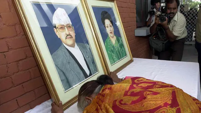 नारायणहिटी राजदरबारको मूलद्वारबाहिर राखिएको राजा वीरेन्द्र र रानी ऐश्वर्यको तस्बिरमा ढोग्दै एक महिला