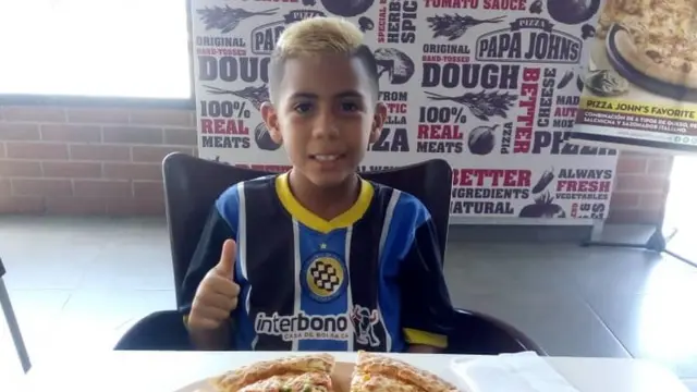 Brayan Navarro comiendo pizza luego de un partido de futbol