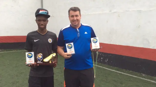 Vini Jr e Cacau segurando troféus