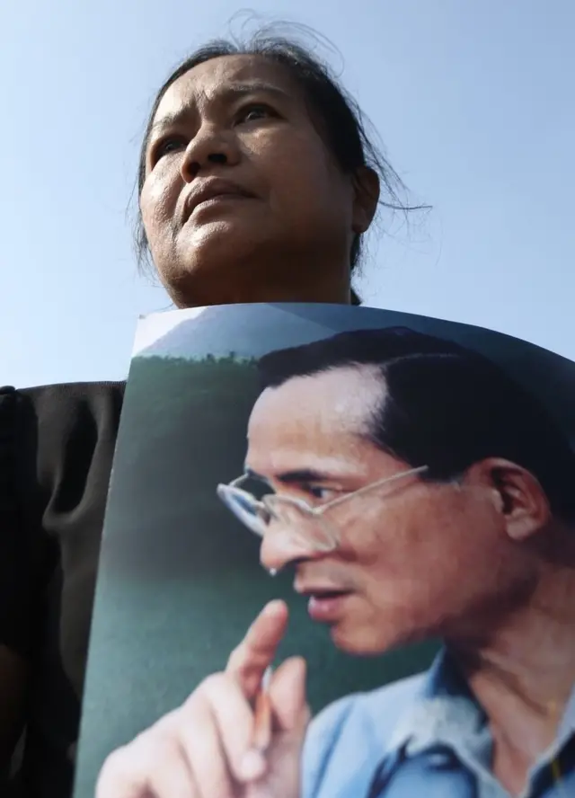 ประชาชนถือพระบรมฉายาลักษณ์ในหลวง ร.9 ขณะเข้าร่วมพระราชพิธีถวายพระเพลิงพระบรมศพฯ