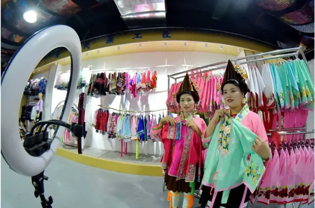 中國貴州省黔東南州的一家服裝公司,苗族婦女通過在線直播銷售刺繡產品(2023年11月5日)。