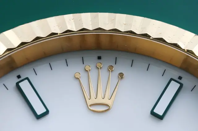Detalle de la corona de 5 puntas que es parte del logo de Rolex en las 12 de un reloj.