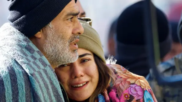 People wrapped in blankets in the aftermath of a deadly earthquake, in Kirikhan, Turkey
