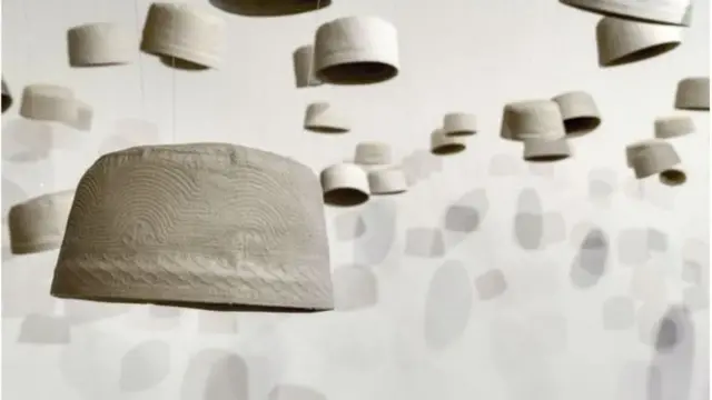 હારુન ગુન સૈલીની મુસ્લિમ નમાઝી ટોપીની કળાકૃતિ. આ કૃતિ ઇમામના અંતિમસંસ્કારમાં સામેલ લોકોનું પ્રતીક છે.