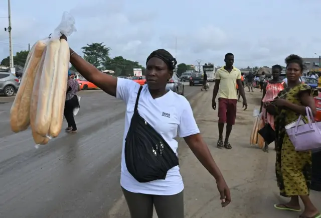 Une vendeuse de pain près de la route.