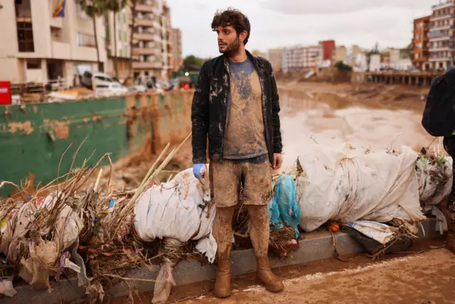 Un joven cubierto de barro en un puente en la localidad de Paiporta. 